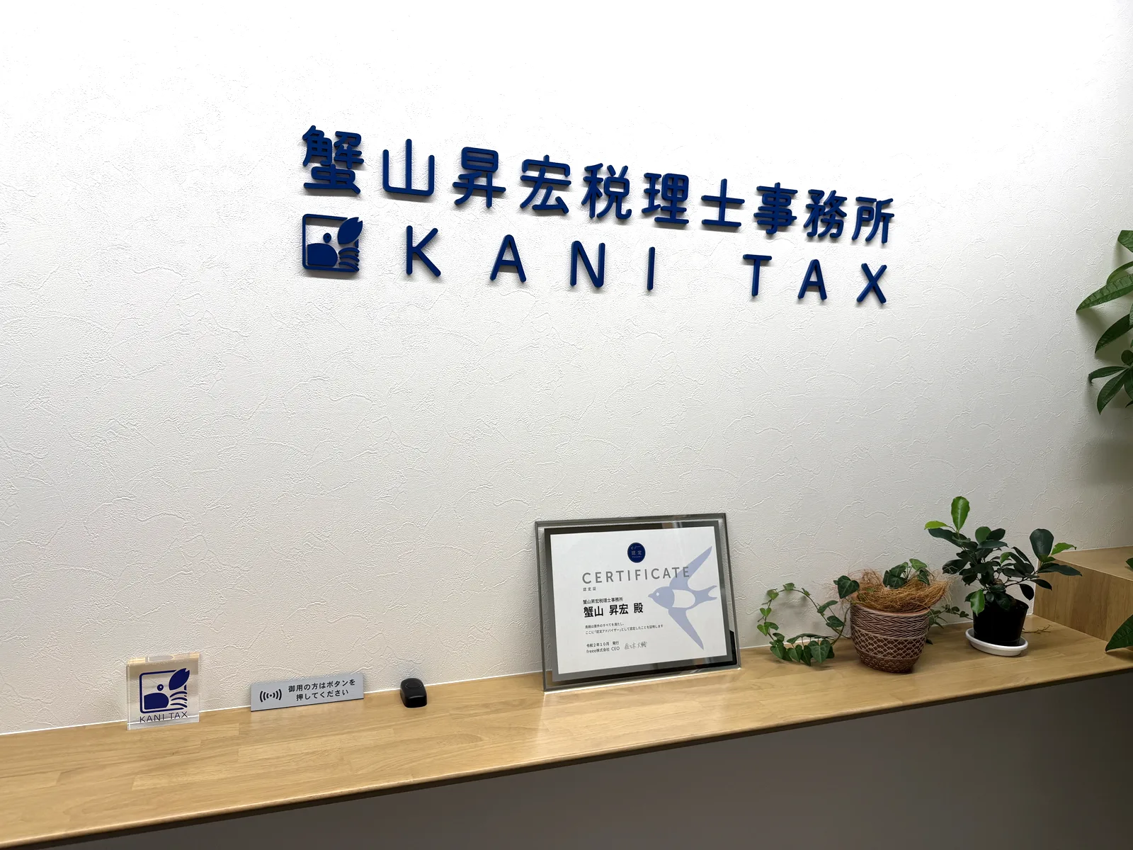 蟹山昇宏税理士事務所の受付。壁面の社名サインとfreee認定アドバイザー認定証